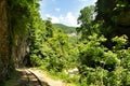 Railway in Guam gorge on one side of the rocks, the other a deep precipice and seething fast river Royalty Free Stock Photo