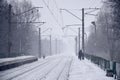 Railway landscape in the cold winter season. Snow-covered railway station platform and foggy overcast sky during a heavy snowfal