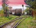 The railway line adjoins the closed lattice metal gate, behind which the rails diverge in two different directions and Royalty Free Stock Photo