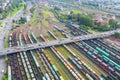 Railway marshalling yard and road bridge above it with cars. Import and export logistics. Industrial landscape. Aerial top view on