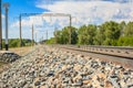 Railway rails in rural areas, passing through the forest. Beautiful sky with clouds. Siberian urban landscape