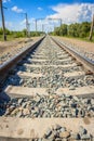 Railway rails in rural areas, passing through the forest. Beautiful sky with clouds. Siberian urban landscape