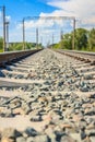 Railway rails in rural areas, passing through the forest. Beautiful sky with clouds. Siberian urban landscape