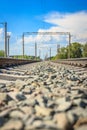 Railway rails in rural areas, passing through the forest. Beautiful sky with clouds. Siberian urban landscape