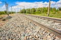 Railway rails in rural areas, passing through the forest. Beautiful sky with clouds. Siberian urban landscape