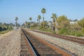 Railway with rusty tracks against houses on a cliff and clear blue sky Royalty Free Stock Photo