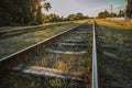 Railway station against beautiful sky at sunset. Industrial landscape with railroad, colorful sky with clouds, sun, trees and Royalty Free Stock Photo