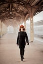 Railway station. Beautiful woman goes from train looking at camera. Female travels light. Middle-aged lady Royalty Free Stock Photo