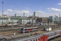 Railway station with a many rail tracks and modern trains and cars on the background of the city, aerial view Royalty Free Stock Photo