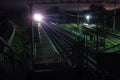 Railway station at night with a passing train Royalty Free Stock Photo