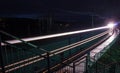 Railway station at night with a passing train Royalty Free Stock Photo