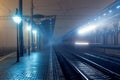 Railway station at night. Train platform in fog. Railroad