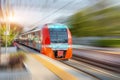 Railway station and passing suburban train with motion blur effect. Convenience concept of passenger transportation urban Royalty Free Stock Photo