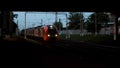 Railway station with a train passing under the road bridge in the late evening. Stock footage. View from under the Royalty Free Stock Photo