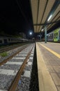 Railway station with train waiting on the tracks at night