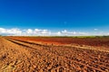 Railway beside sugar cane field after harvest on blue sky day Royalty Free Stock Photo