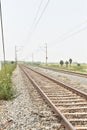 Railway track with the background of sky, and green trees on both sides of the track Royalty Free Stock Photo