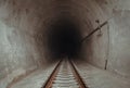 Railway track leading lines into the dark train tunnel entrance Royalty Free Stock Photo