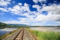 Railway Track by Water Rice Fields Vanishes into Space