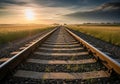 Railway tracks extend into the horizon under a dramatic sky as the sun sets. The tracks, surrounded Royalty Free Stock Photo