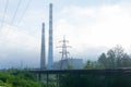 Railway tracks going into the fog, pipelines and chimneys in the haze Royalty Free Stock Photo