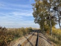 Railway tracks in the middle of the forest and field with trees in autumn Royalty Free Stock Photo