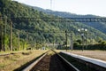Railway tracks and the platform of station against background of high Carpathian mountains Royalty Free Stock Photo