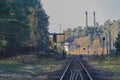 Railway tracks running through the autumn forest towards an industrial plant - a steelworks. Royalty Free Stock Photo