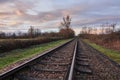 Railway tracks in rural scene and distant sunset Royalty Free Stock Photo