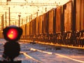 Railway traffic light shows blue signal on railway with blur effect and railway with freight train as the background Royalty Free Stock Photo