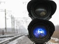 Railway traffic light shows blue signal on railway on cloudy day.