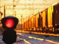 Railway traffic light at sunset shows red signal on railway Royalty Free Stock Photo