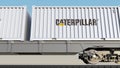 Railway transportation of containers with Caterpillar Inc. logo. Editorial 3D rendering