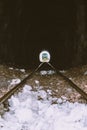 Railway tunnel with train at the end. Green locomotive at the end of tunnel. Transportation and travel concept. Royalty Free Stock Photo