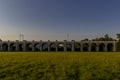 Railway viaduct with passing trains and cars in an underpass during a sunny day with moving clouds in the sky Royalty Free Stock Photo