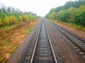 Railway. View from the window of the last train car or from the cab. Russian autumn landscape. Railway rails and sleepers Royalty Free Stock Photo
