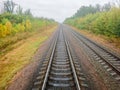 Railway. View from the window of the last train car or from the cab. Russian autumn landscape. Railway rails and sleepers Royalty Free Stock Photo