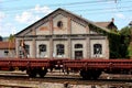 Railway wagon composition in front of old railway station with dilapidated walls and broken windows Royalty Free Stock Photo