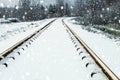 Railway in winter. Winter railway in the forest. Railway in the snow. Winter landscape with empty railway tracks. Snow falls. Road Royalty Free Stock Photo