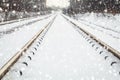 Railway in winter. Winter railway in the forest. Railway in the snow. Winter landscape with empty railway tracks. Snow falls. Road Royalty Free Stock Photo