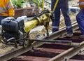 Railway workers bolting track rail. Detail worker with mechanical bolting wrench Royalty Free Stock Photo