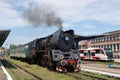 Railways, steam locomotive with wagons standing the station, the electric train in the background Royalty Free Stock Photo