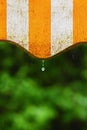 Rain. Awning on a balcony and drops of water on a natural colorful background during a spring day Royalty Free Stock Photo