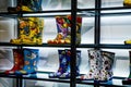 rain boots with cartoon characters on underlit glass shelves