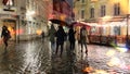 Rain in the city evening rainy urban street people walk with umbreellas city bokeh blurred light wet pavement medieval houses i