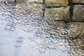 Rain in the city - puddles on the cobblestone street pavement -