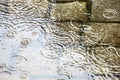Rain in the city - puddles on the cobblestone street pavement -
