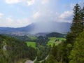 Rain cloud raining a shower of rain over a mountain village with blue sky in Austria Royalty Free Stock Photo