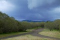 Rain clouds on bifurcation of dirt road in Etna Park Royalty Free Stock Photo