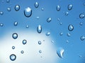 Rain drop on glass against blue sky and few cloud. Royalty Free Stock Photo